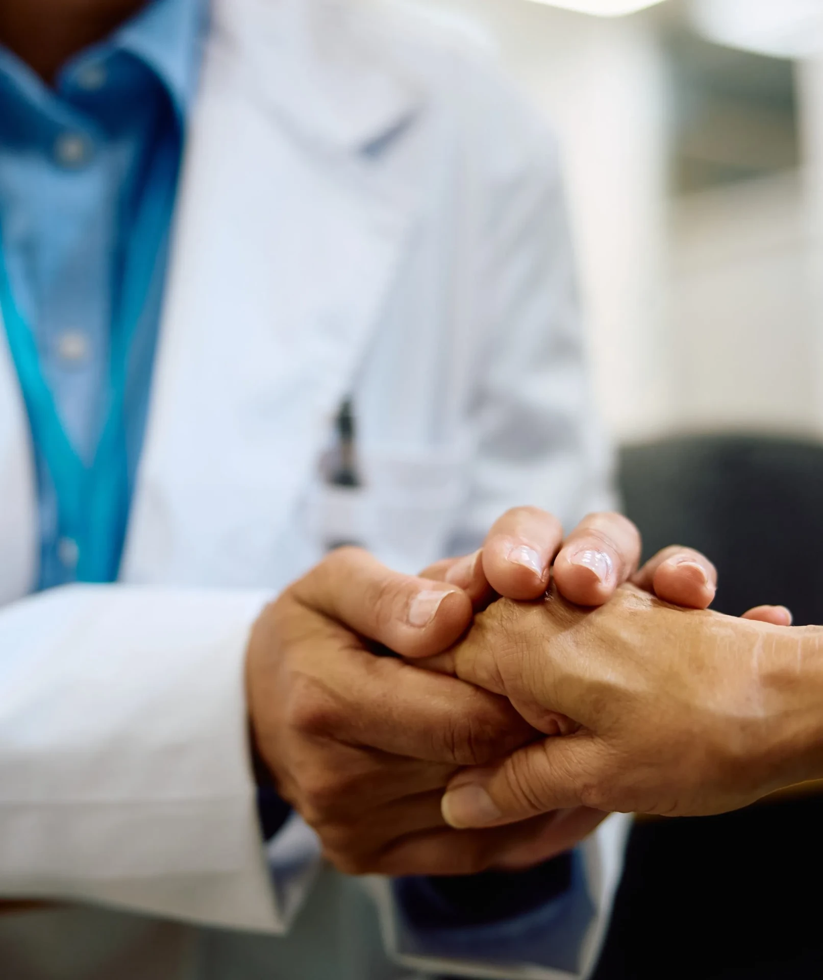 A Pulse Healthcare System clinician holding a patient's hand in compassionate care